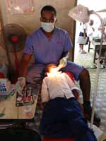 Oral health student Mr Rhema Ndukwe with a patient in Cambodia.