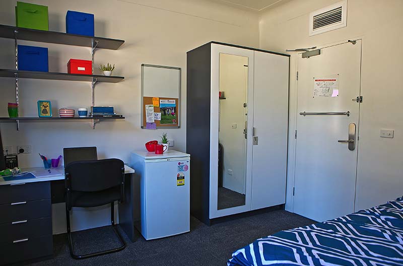 Wide view of a room showing study area and wardrobe storage