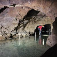 Peter keeping his feet dry while inspecting a flooded cave.