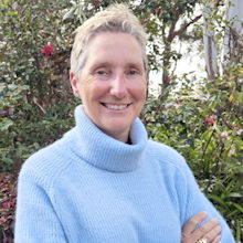 Photo of Emma Bowen with a blue jumper and trees in the background