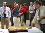 Head of the CSU School of Animal and Veterinary Sciences Professor Kym Abbott cuts a birthday cake for Charles Darwin.