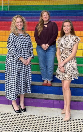 Innovation hub team standing on a colourful staircase.