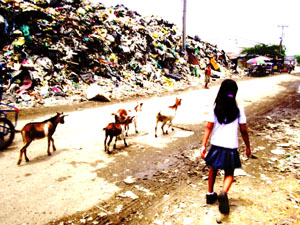 Girl on her way to school in a Innayawan rubbish dump in the Philippines