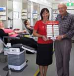 Mrs Helen Cavalieri from the Red Cross Blood Service (left) presents the Club Red Corporate Challenge trophy to Mr John Eyles from CSU.