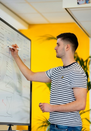 People designing an app using sticky notes and drawing on paper.