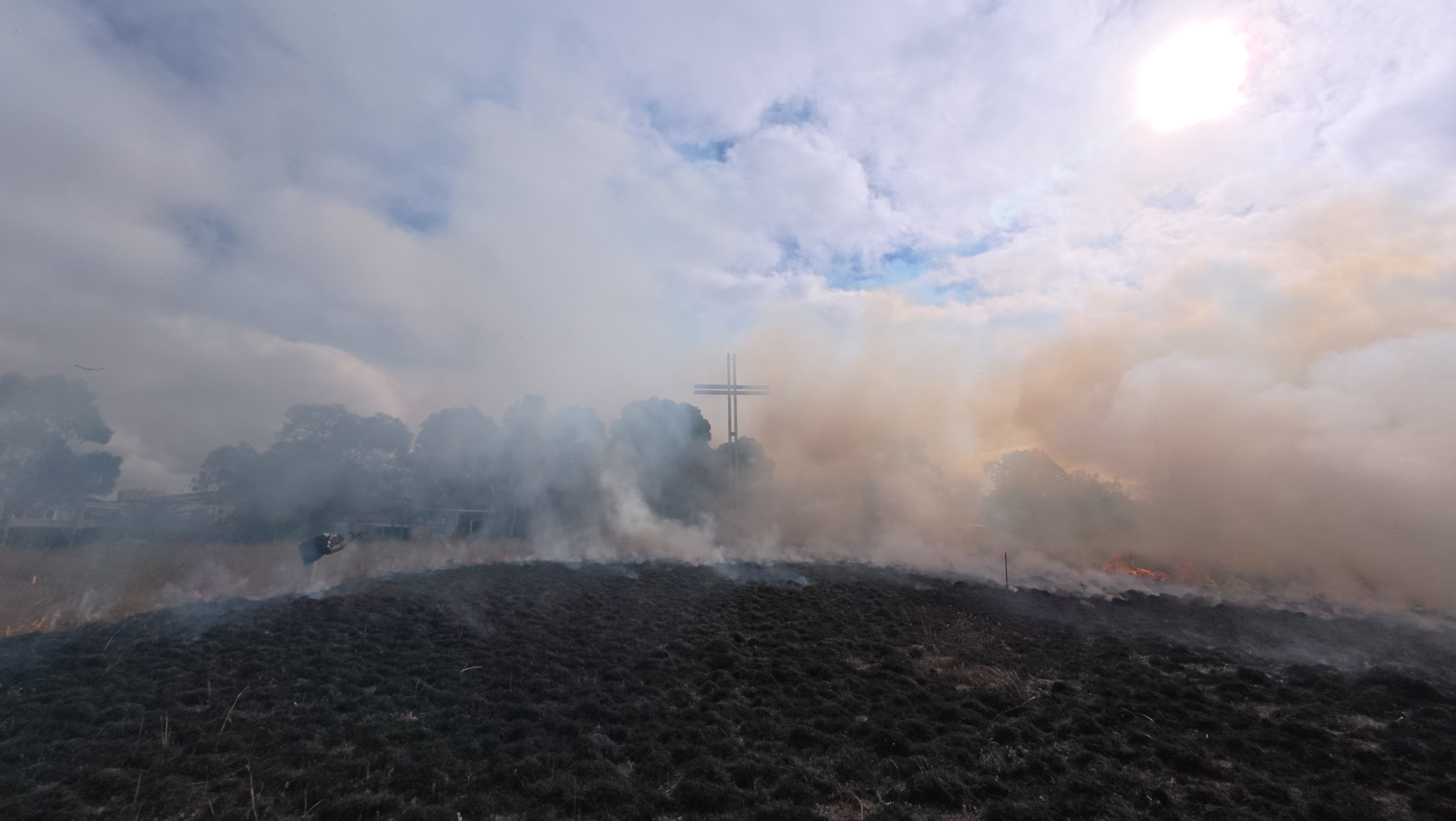On the edge View of the great cross through the smoke across the burnt grassland
