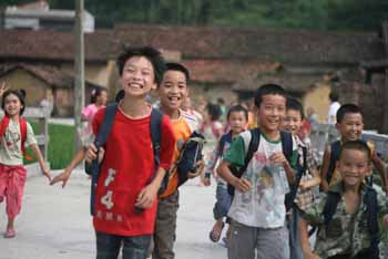 In Shangmingtai village in Guangxi province, China, school children run home from school across the new bridge which helps keep them safe from flood waters. Photo: Australian Red Cross/Li Feng