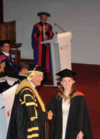CSU senior education lecturer Dr Colin Boylan (background) watches as his daughter Amy is awarded a double degree by the Chancellor Mr Lawrence Willett AO at the graduation on Tuesday 13 December. 