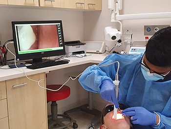 A student records a patient using an intraoral camera