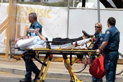 Paramedics moving a patient on a guerney