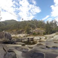 A view from the rocky surface below the bridge, near the river.