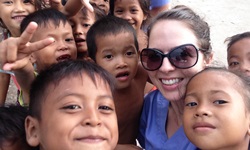 Photo of CSU student Ms Kimberly Smithson with children in Cambodia