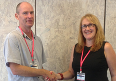 Associate Professor Barney Dalgarno is congratulated by ascilite president Dr Caroline Steele