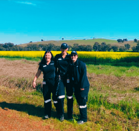 Rural Health students standing in front of a paddock of flowering canola.