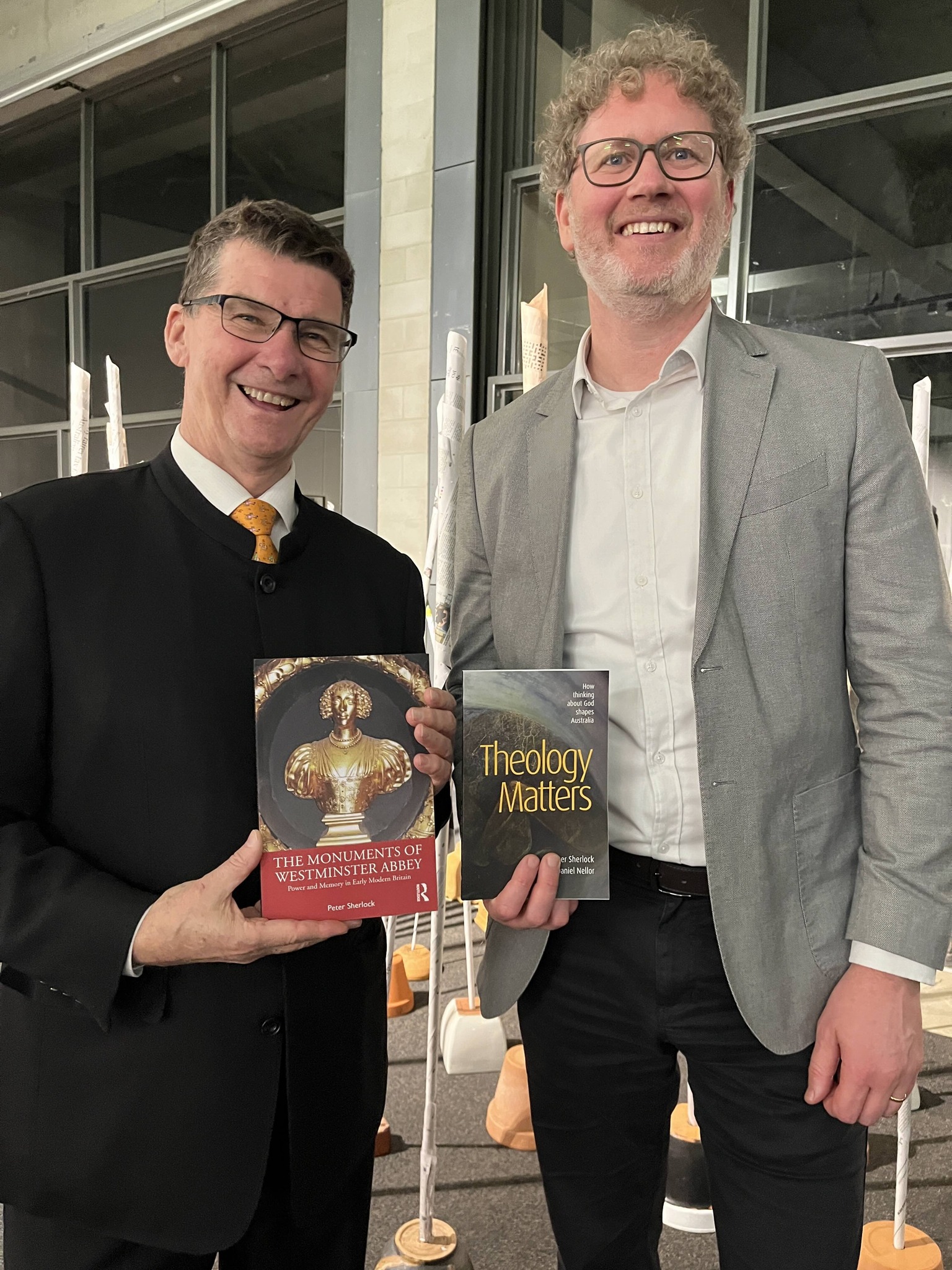 Brendan Smythe and Jonathan Cole holding Peter Sherlock's books